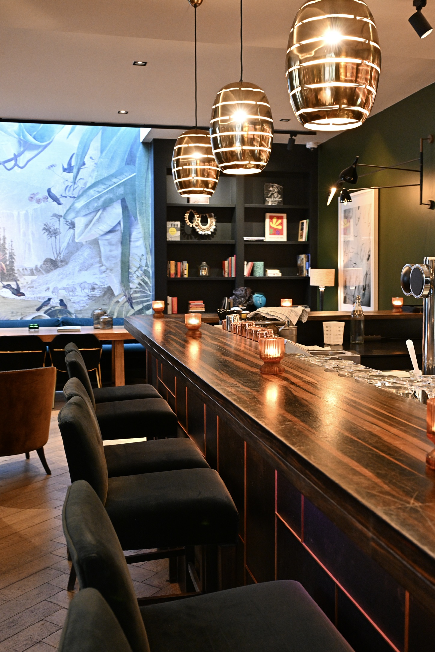 Hotel FRANQ wooden bar with black stools and golden pendant lights