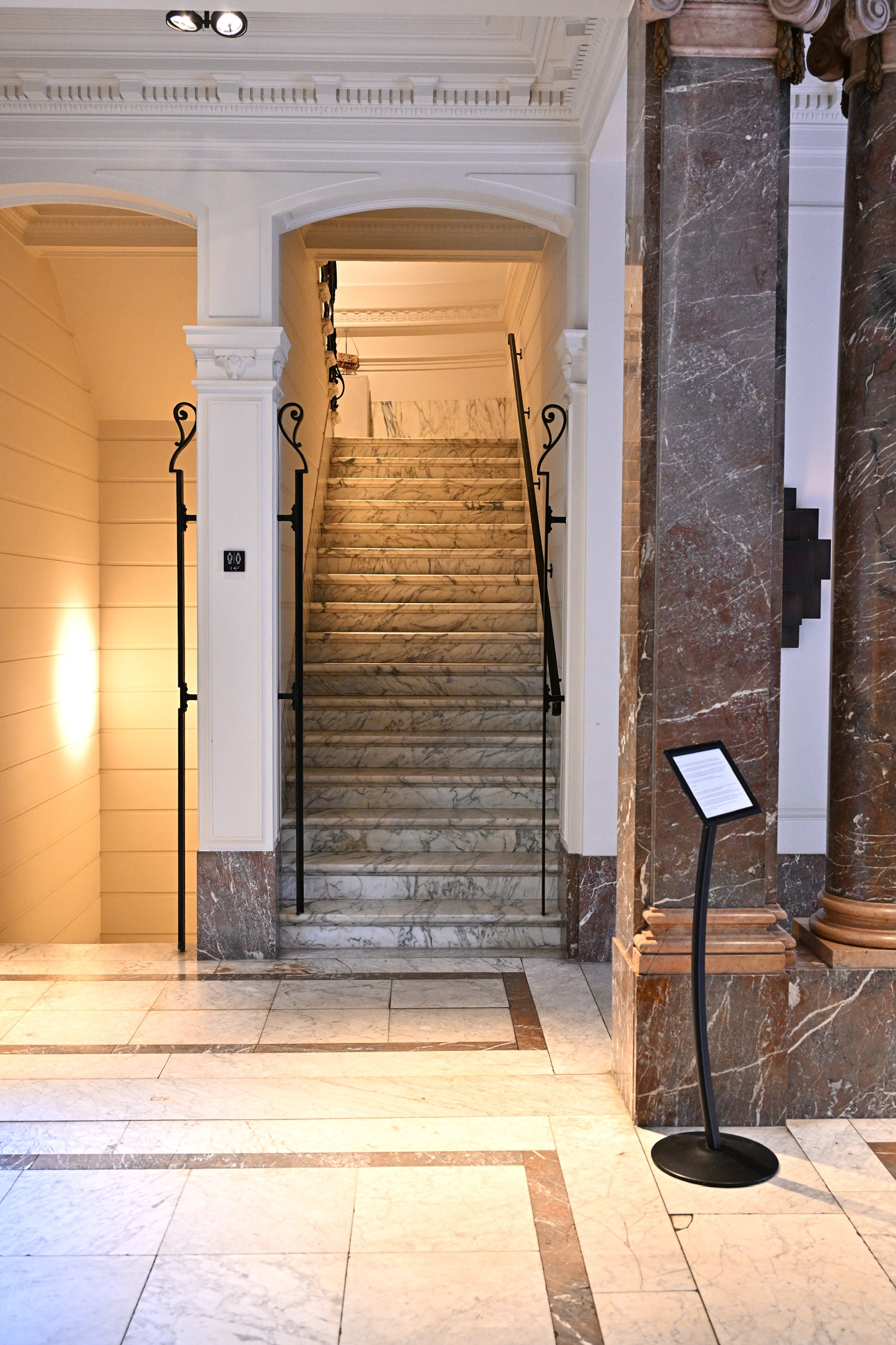 Marble staircase of the former bank with a wrought-iron balustrade and arch